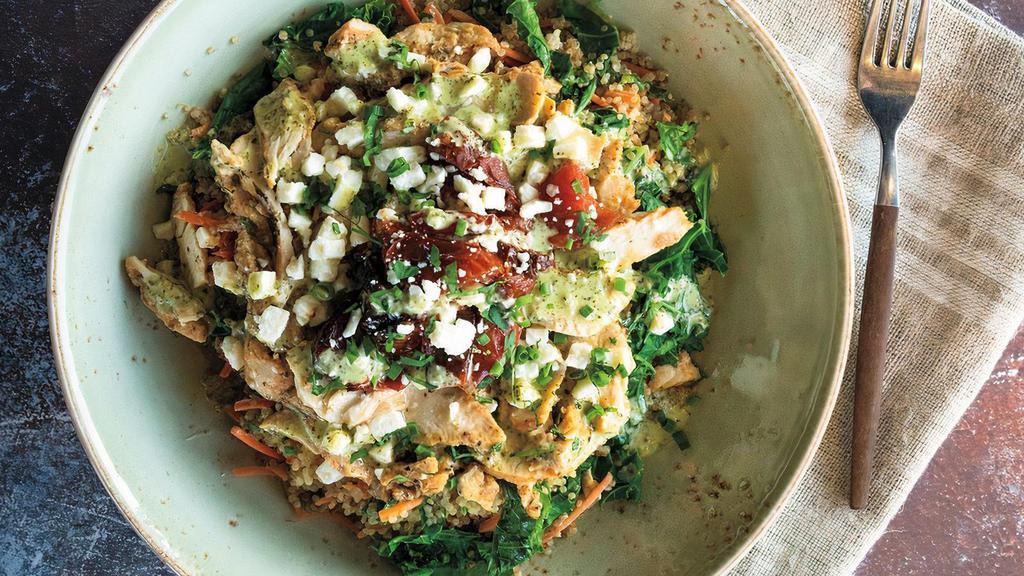 Pesto Chicken Quinoa Bowl · Protein-packed quinoa mixed with kale, shredded carrots and house-roasted tomatoes topped with grilled all-natural lemon chicken breast, basil pesto sauce, feta crumbles and fresh herbs.