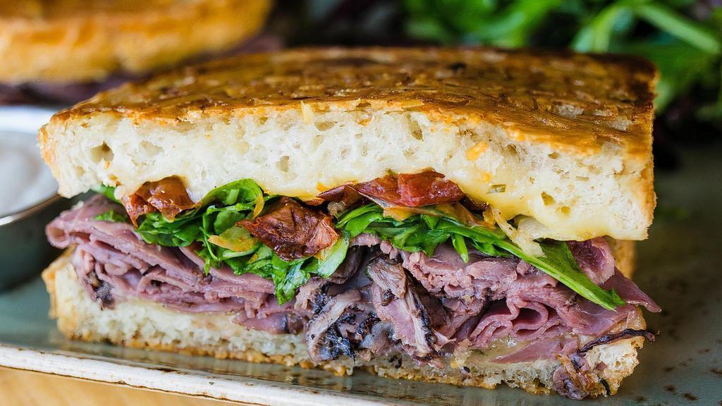 Roast Beef & Havarti Sandwich · Roast beef, Horseradish Havarti, house-roasted onions and tomato with lemon dressed arugula on grilled Parmesan-crusted sourdough, Horseradish sauce on the side. Served with lemon-dressed organic mixed greens or a bowl of tomato basil soup.