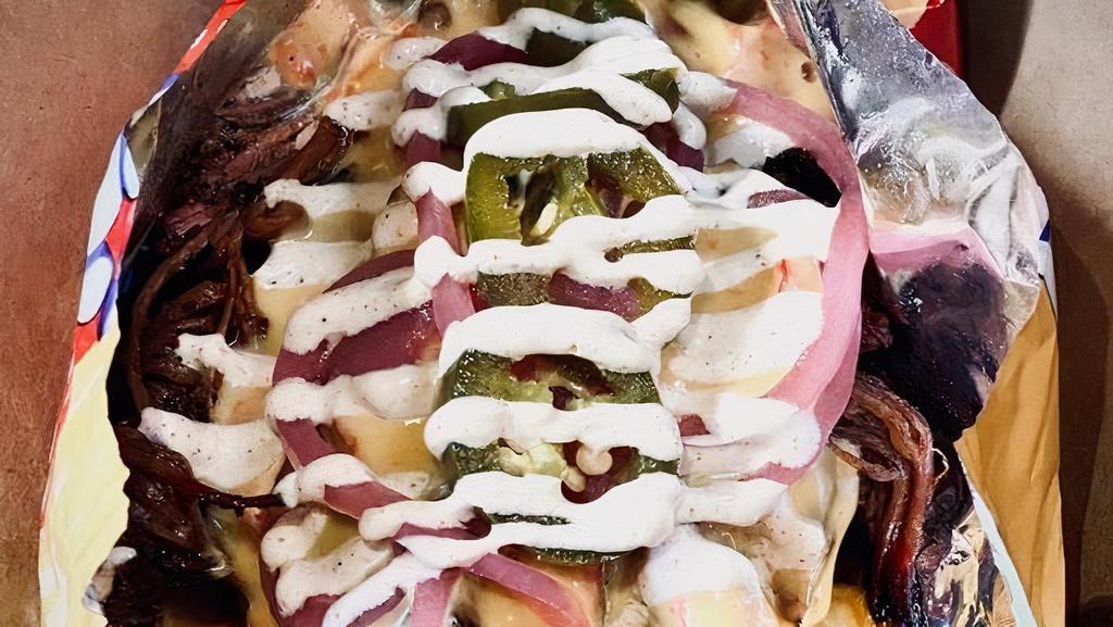 Frito Pie · BAG OF FRITOS w/Texas Red Chili, Queso, Pickled Jalapenos, Red Onions & Lime Crema