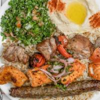 Mixed Grill Combo · three meats served on a bed  of rice w vermicceli or salad served with sauce,pickles and pita