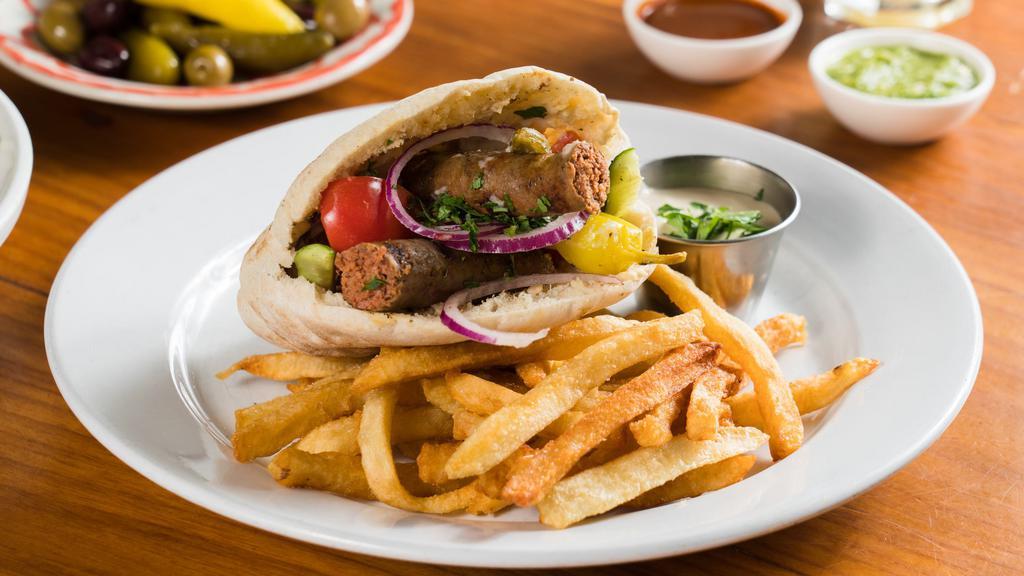 Tunisian Sandwich · Homemade Spicy Merguez Sausage, Hummus, Tahini and Salad in Pita Bread. Served with a choice of Fries or Salad.