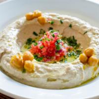 Hummus Plate · Served with warm chickpeas, schug, tomato, onion, parsley and olive oil