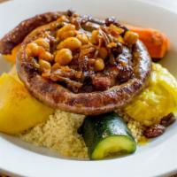 Homemade Merguez Sausage Couscous · Served with vegetables, bouillon, chickpeas, caramelized onions and raisins.