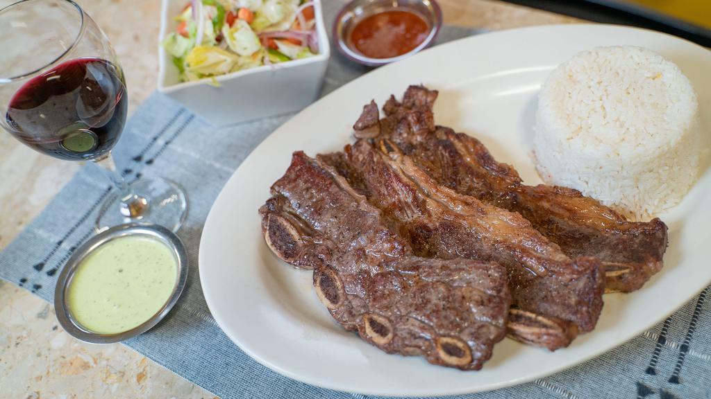 Costillas A La Parrilla · Grill ribs served , with rice and salad