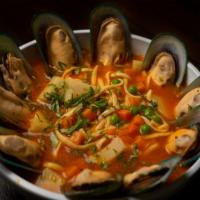 Sopa De Choros · Fresh mussel noodle soup with potatoes and topped with cilantro.