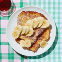 Le Banana French Toast · Just say “oui” to this delicious dish. Classic French toast topped with bananas and syrup on...