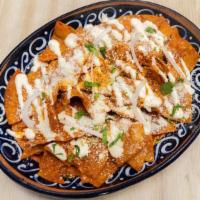 Chilaquiles Verdes O Rojos · Tortilla chips cooked with choice of red or green sauce, topped with Mexican cream, fresh ch...