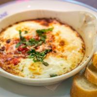 Baked Eggs With Tomato · Three eggs, tomato sauce, fresh basil, French baguette.