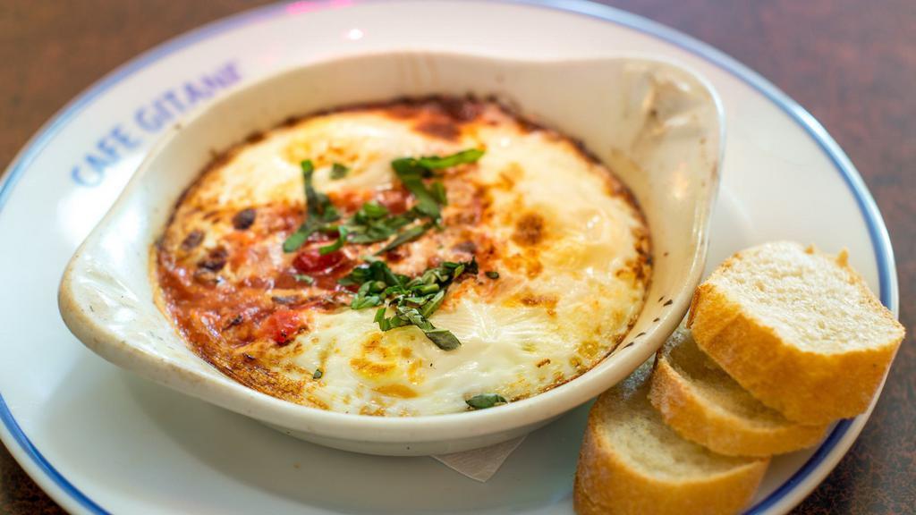 Baked Eggs With Tomato · Three eggs, tomato sauce, fresh basil, French baguette.