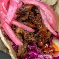 Korean Bbq Taco · Beef brisket, red cabbage slaw, pickled onion, and gochujang.