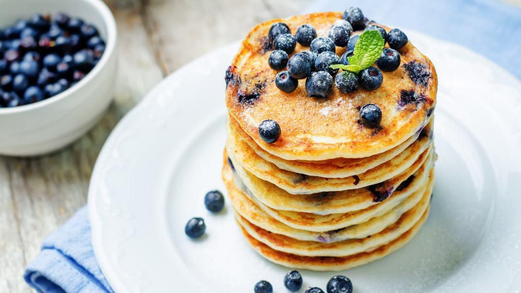 Blueberry Buttermilk Pancakes · 3 perfectly fluffy blueberry pancakes served with a side of butter and syrup.