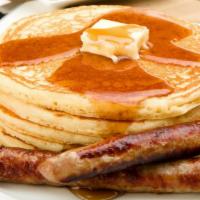 Sausage Buttermilk Pancakes · 3 perfectly fluffy pancakes topped with sausage served with a side of butter and syrup.