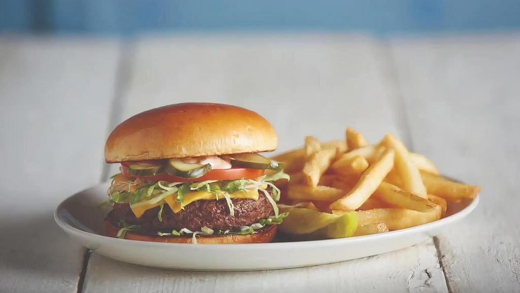 Cheeseburger In Paradise · Our signature burger topped with American cheese, lettuce, tomato, and pickles. 720 cal.