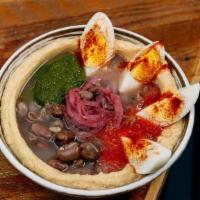 Hummus Ful · Hummus topped with tahini, stewed fava beans, grated tomato, green schug, sumac red onion an...
