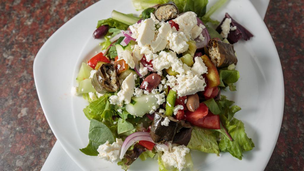 Greek Salad  · Romaine, mixed baby greens, Bermuda onions, tomatoes, green peppers, cucumber, Kalamata olives, stuffed grape leaves, peperoncini and feta cheese topped with red wine vinaigrette.