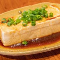 Soft Tofu With Secret Sauce · Raw tofu with salty sweet sauce and topping with sliced scallion.