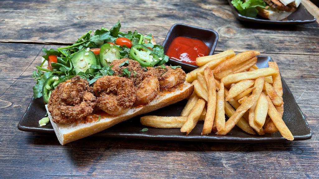 New Orleans Shrimp Po' Boy · French baguette, buttermilk battered shrimp, cayenne pepper creole remoulade, watercress, cherry  tomatoes, served with five spiced fries.