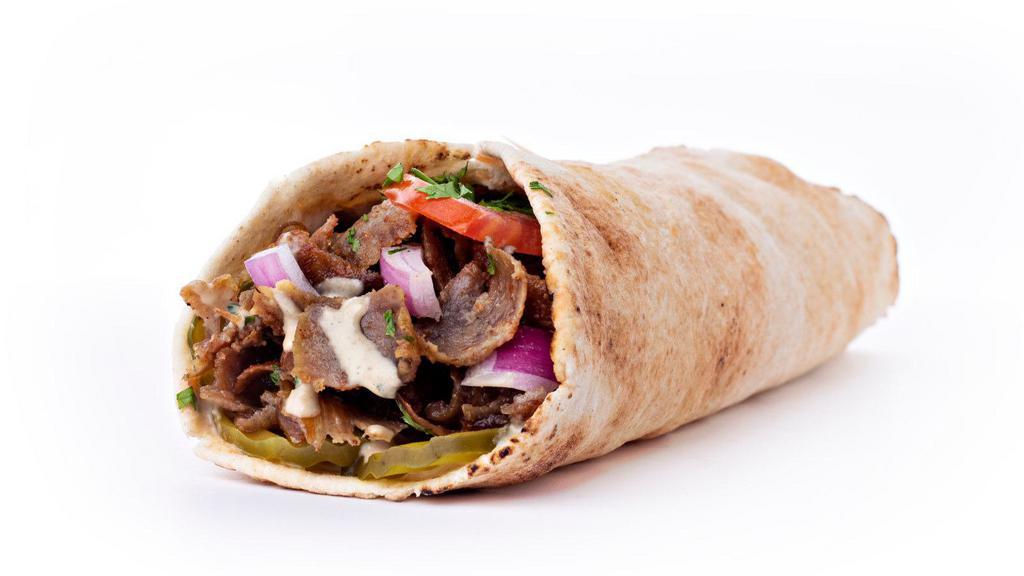 Shawarma Sandwich · Juicy, marinated, thinly sliced top sirloin, seasoned and slow roasted to perfection. Wrapped in a warm pita and topped with fresh tomatoes, lettuce, house pickles and tahini dressing.