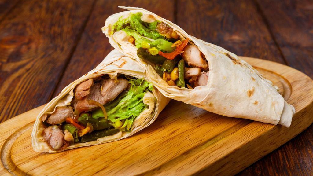 Shish Tawook (Grilled Chicken) Sandwich · Tender, marinated chicken breast pieces, grilled to perfection. Wrapped in a warm pita and topped with fresh tomatoes, lettuce, house pickles and tahini dressing.