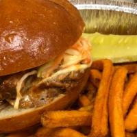 Pulled Pork Sandwich · BBQ pulled pork sandwich on a brioche bun topped with cole slaw served with sweet potato fri...