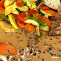 Steak Au Poivre · Pan seared 14 oz. NY strip steak topped with a peppercorn brandy cream sauce served with roa...