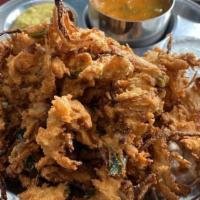 Onion Pakoda · Spiced onion fritters mixed with cilantro and chickpea flour and served with chutney and sam...