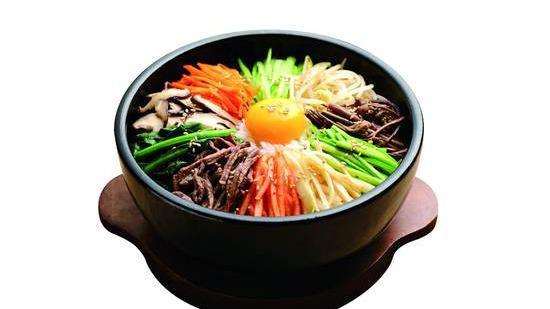Dol Pan Sot Bi Bim Bap · Rice topped with vegetables on a sizzling stone pan with a fried egg and choice of protein.