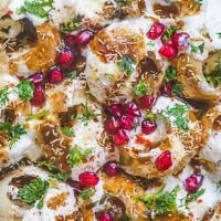 Dahi Puri · Crispy shells filled with lentils and potatoes, topped with sev, yogurt, coriander, pomegran...