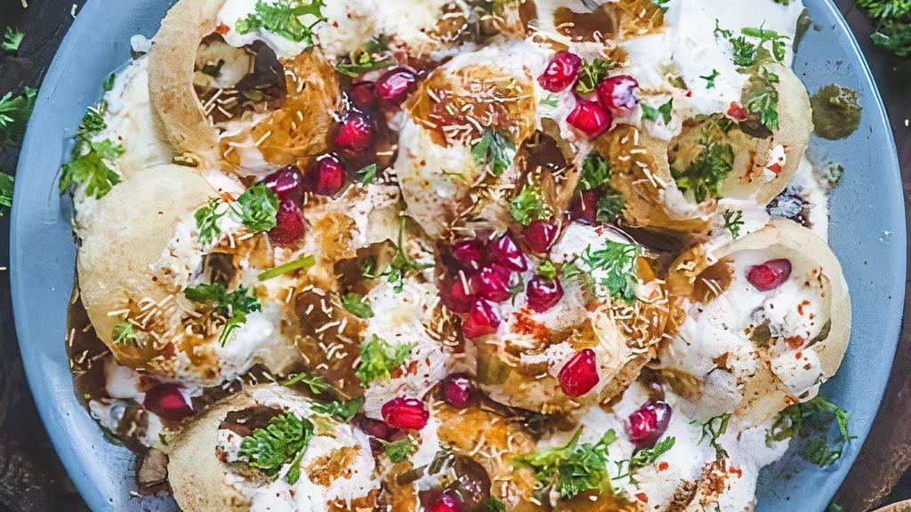 Dahi Puri · Crispy shells filled with lentils and potatoes, topped with sev, yogurt, coriander, pomegranate and tamarind chutneys.