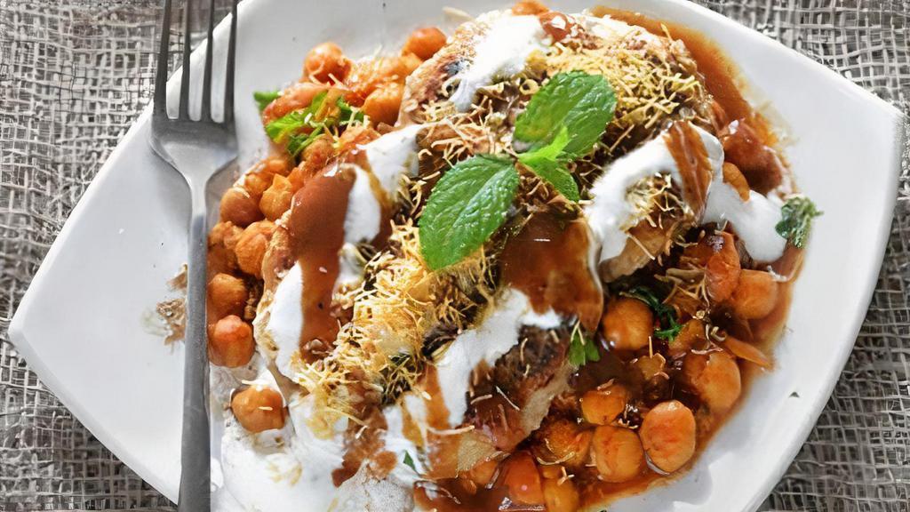 Aloo Tikki Chaat · Hot and crispy served with some of the most delicious toppings such as tamarind chutney, green chutney, sev, ragda, curd, finely chopped onions, pomegranate seeds and various other aromatic spices.