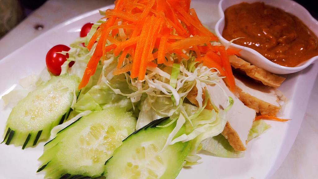 Thai Salad · Iceberg lettuce, tomatoes, cucumber, red onion, and bean curd. Served with peanut dressing.