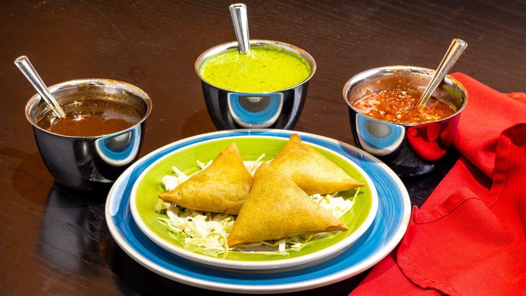 Vege / Meat Samosas · Crispy turnover stuffed with a choice of vegetable or ground lamb.