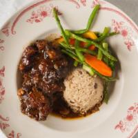 Smothered Oxtail · Popular Item. Served with a choice of rice and peas, spinach, coconut rice or steamed ground...