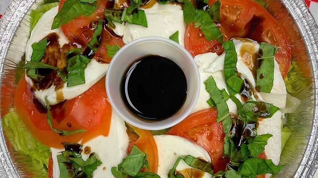 The Caprese Salad · Fresh mozzarella, thinly sliced tomato, iceberg lettuce and topped with fresh basil and a balsamic glaze.