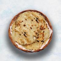 Butter Naan · Indian white flour flatbread baked to perfection in a traditional Indian clay oven and glaze...