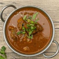 Indian Goat Curry · Homestyle goat curry on the bone simmered in an authentic Indian herbal sauce.