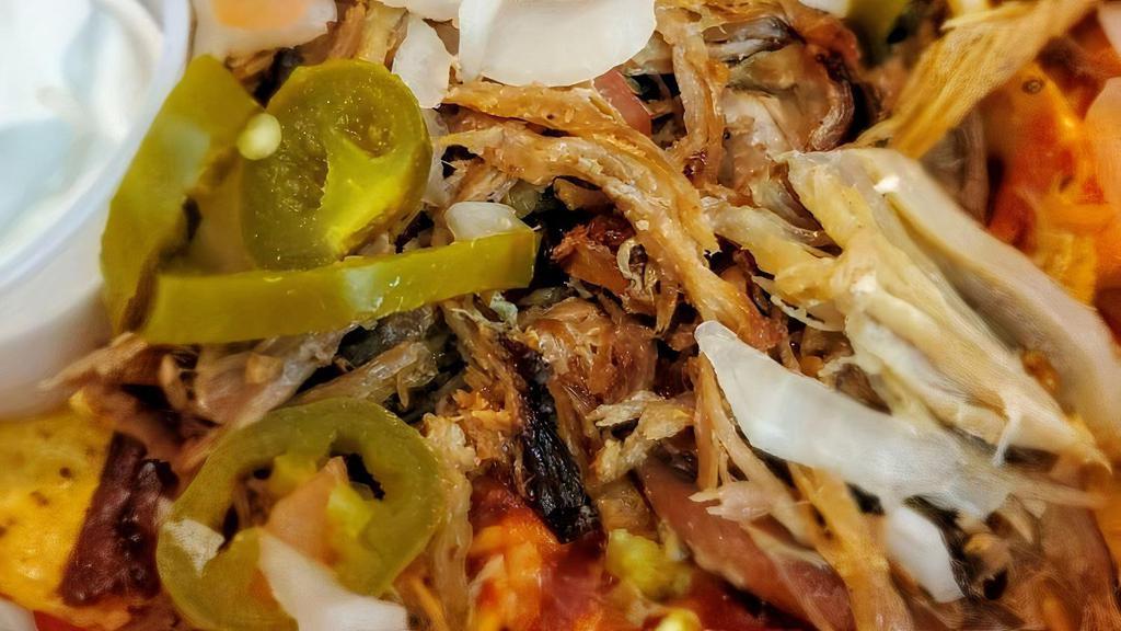 Kalua Pig Nachos · Popular. Nachos piled high with tortilla chips, melted shredded Cheddar cheese, Kalua pig, diced tomatoes, cilantro, and onions. Topped with sour cream, guava BBQ, and jalapeños.