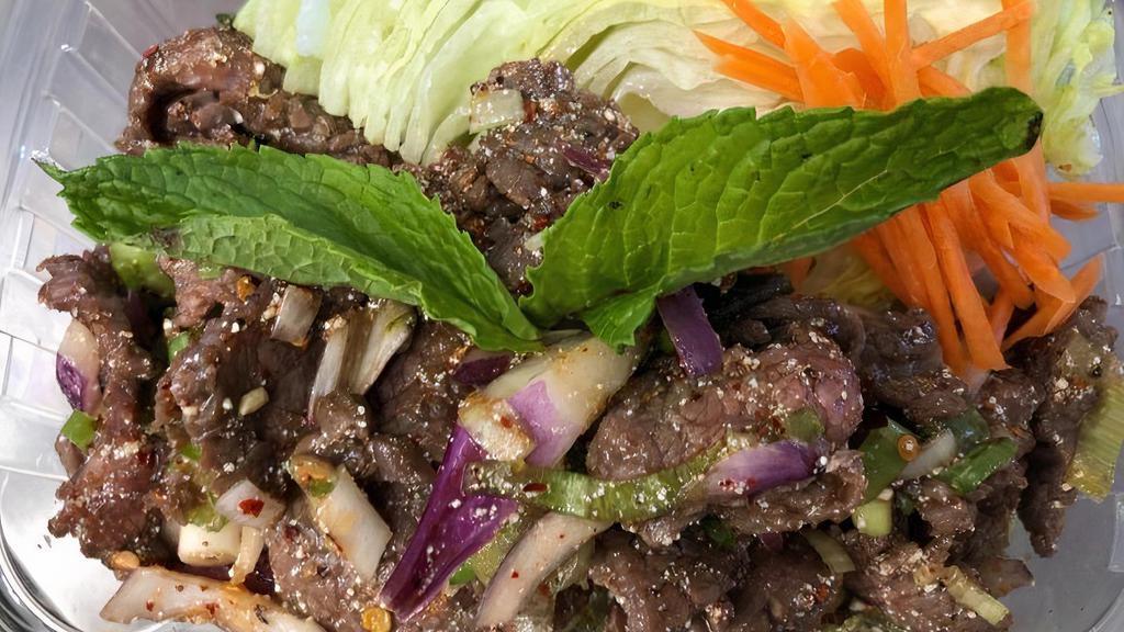 Beef Salad · Spicy. Slices of grilled beef tossed in spicy lime juice dressing, red onions, scallions, rice powder, and mint leaves on lettuce.