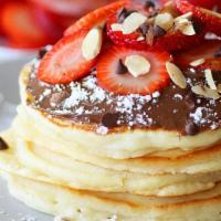 Nutella Pancakes · 3 buttermilk pancakes topped with Nutella and powdered sugar and comes with syrup and butter...