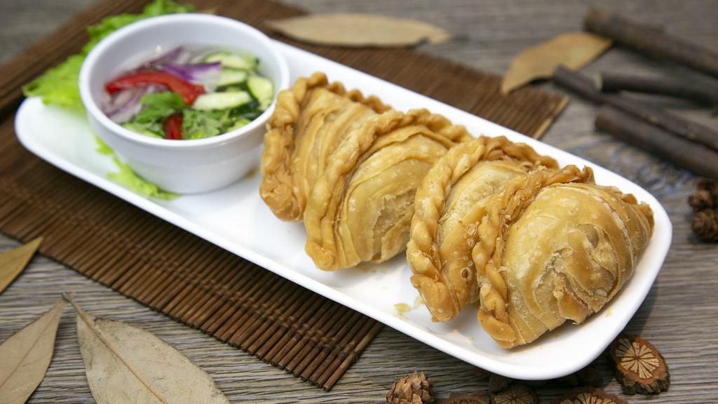 Chicken Curry Puff · Crispy pastry pouch of chicken, potato and onion. Served with ajad salad (cucumber, shallot, sweet chili sauce and peanuts).