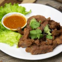 Marinated Pork Strips · Served with jaew (tart chili-lime sauce).