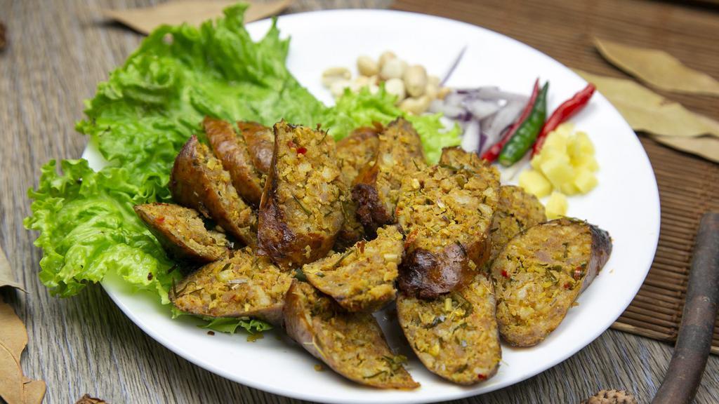 Sai Oua Sausage · Northern-style herbed pork sausage, fresh ginger, peanuts, Thai chili and red onion.