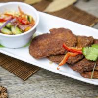 Tod-Mun (Fried Fish Cakes) · Soft, red curry and herb fish cakes, served with ajad salad (cucumber, shallot, sweet chili ...