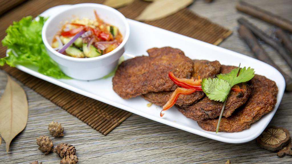 Tod-Mun (Fried Fish Cakes) · Soft, red curry and herb fish cakes, served with ajad salad (cucumber, shallot, sweet chili sauce and peanuts).