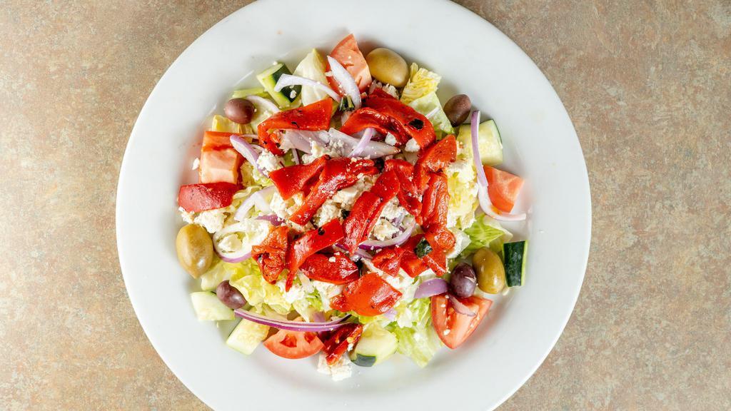 Greek Salad · iceberg lettuce topped with red onions, black olives, tomatoes, cucumbers, roasted red peppers, stuffed grape leaves, and crumbled feta cheese, and served with greek vinaigrette dressing on the side.