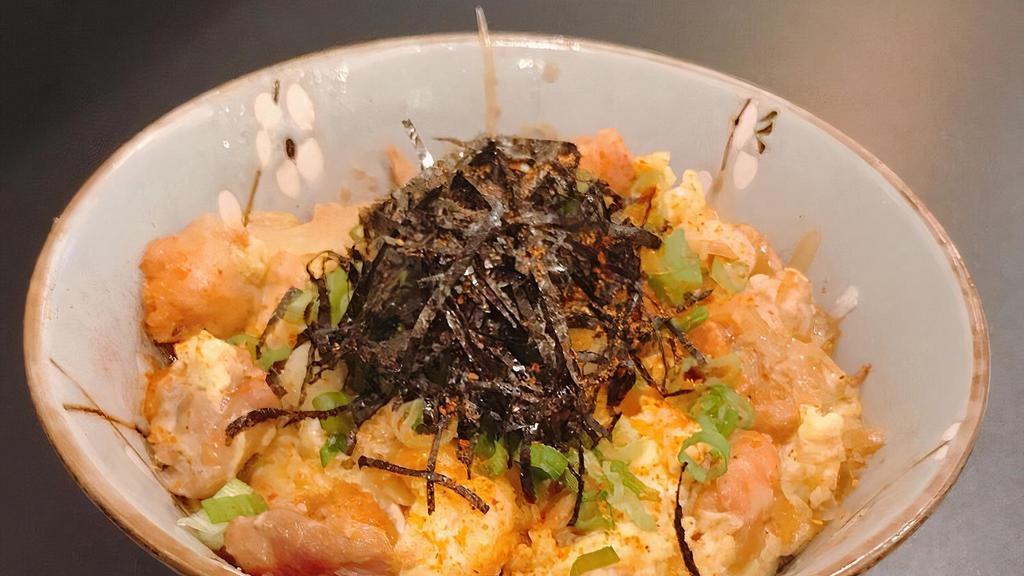 Chicken · Chicken and egg with stir-fried onions over rice, negi, spicy powder, and nori flakes.