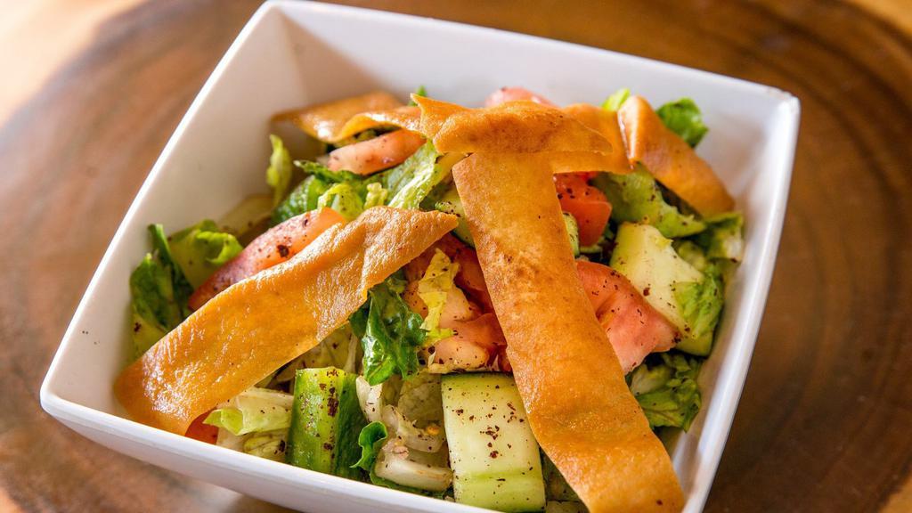 Fattoush · Vegetarian. Mixture of greens with cucumber, tomatoes, onions, mint, bell peppers, sumac and extra virgin olive oil, served with toasted pita crisps.
