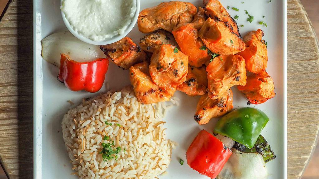 Shish Tawook · Marinated chicken breast cubes with toum*. Served with rice and grilled vegetables.