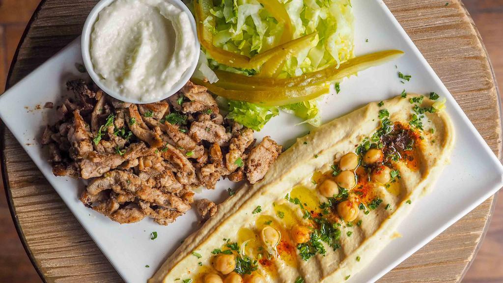 Hummus Shawarma · Our balade hummus with beef shawarma, tomatoes, scallions, parsley, sumac and onions. Served with pickles and tahini sauce.