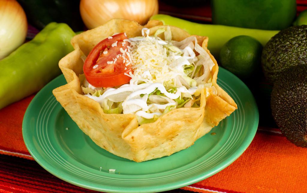 Taco Salad · A fried flour tortilla with your choice of ground beef or shredded chicken, topped with cheese sauce, lettuce tomato, sour cream, and guacamole.